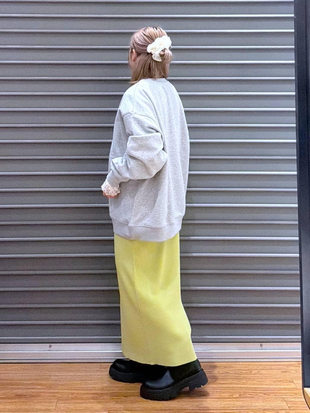 グリーン系のスカート、ブラック系のブーツ、グレー系のスウェットを着用したレディースの冬コーディネートの3枚目の写真