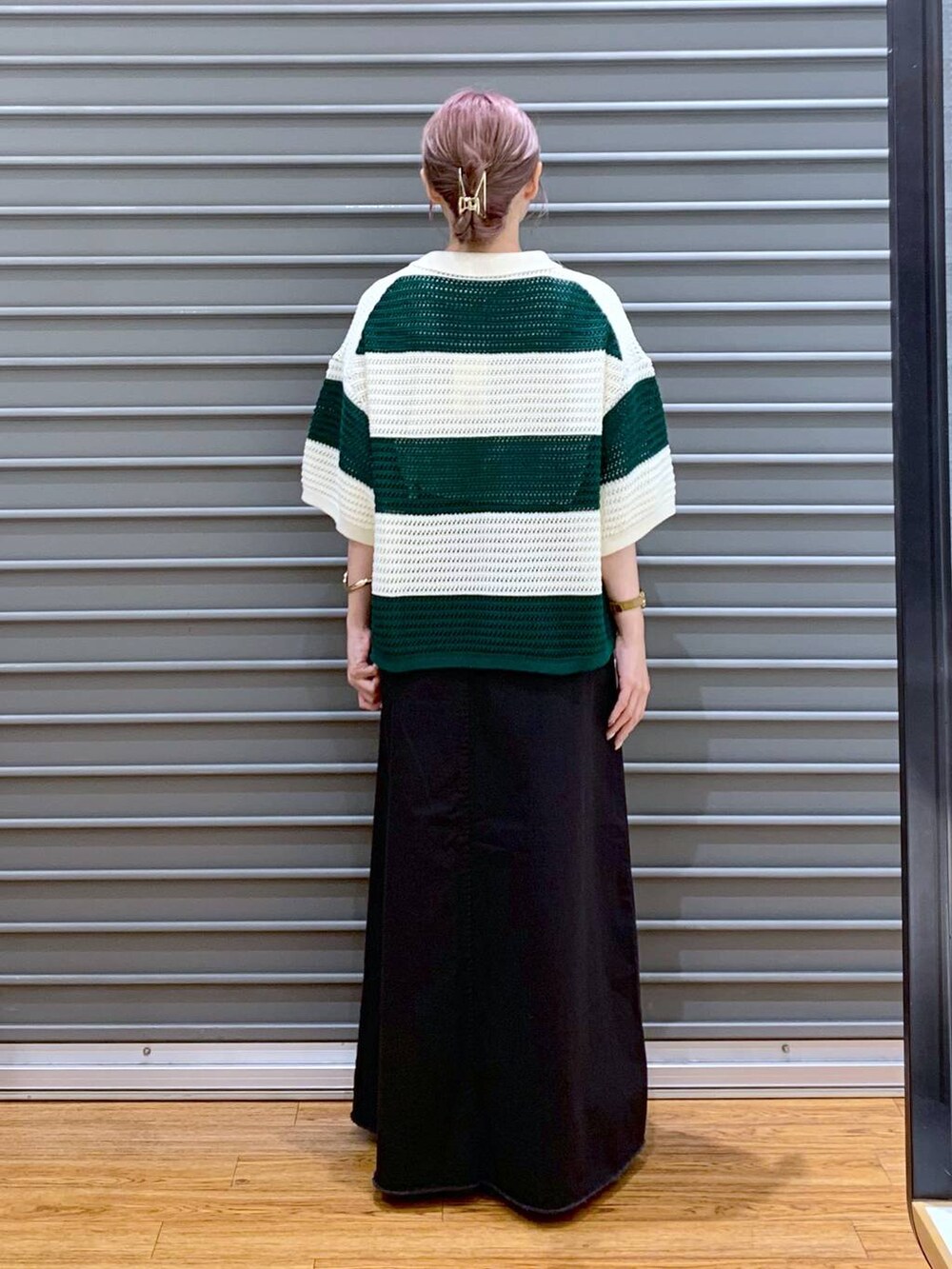 グリーン系のニット/セーター、グレー系のスカート、ブラウン系のボストンバッグを着用したレディースの秋コーディネートの2枚目の写真