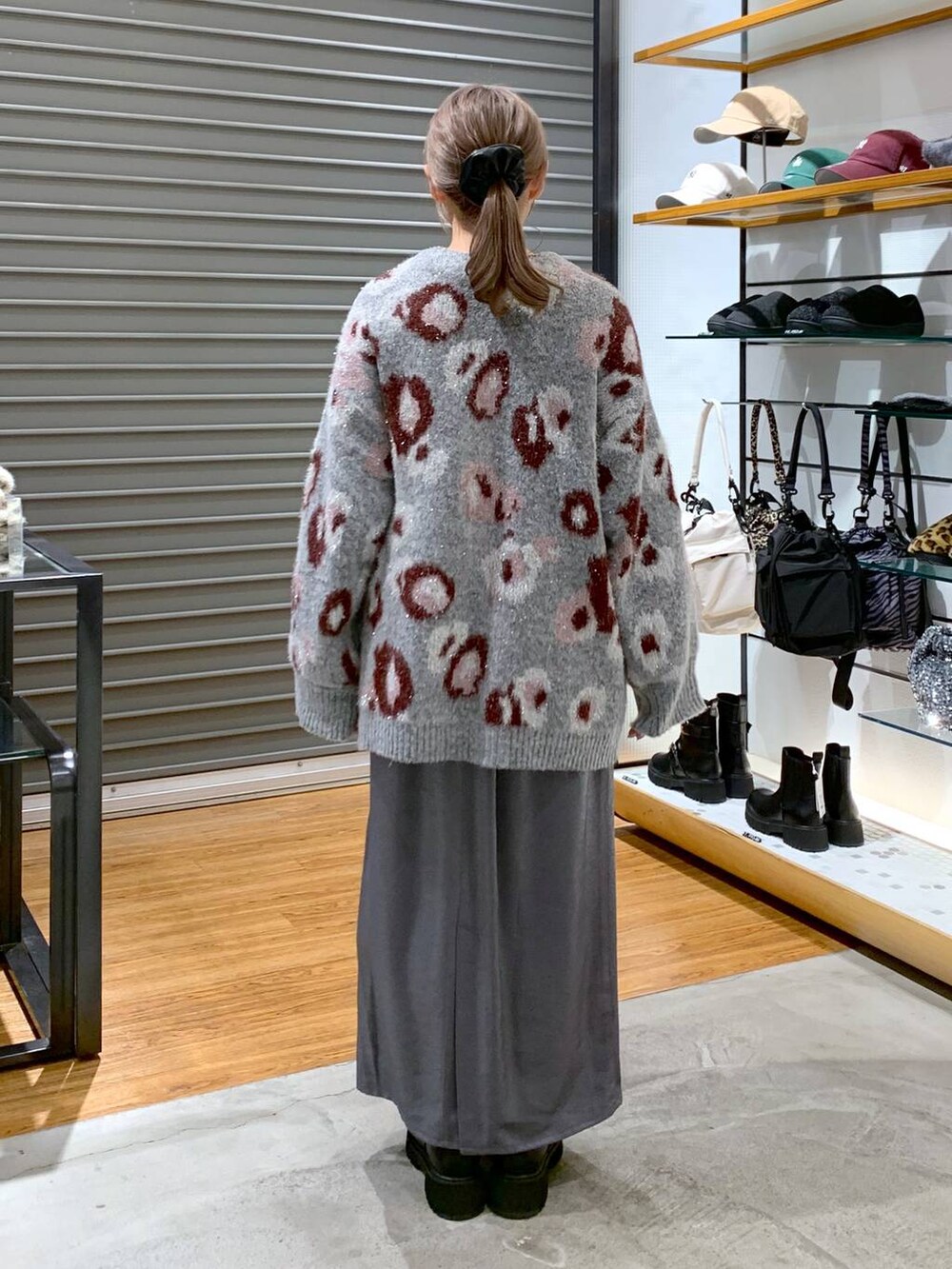 ホワイト系のショルダーバッグ、ブラック系のブーツ、ブラック系のスカートを着用したレディースの冬コーディネートの2枚目の写真