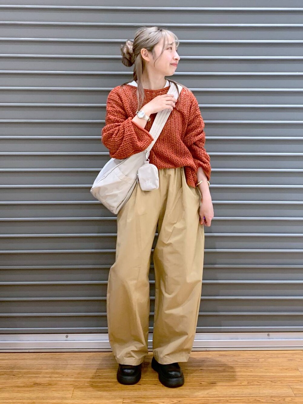 レッド系のニット/セーター、ホワイト系のショルダーバッグ、ブラック系のサンダルを着用したレディースの春コーディネートの3枚目の写真