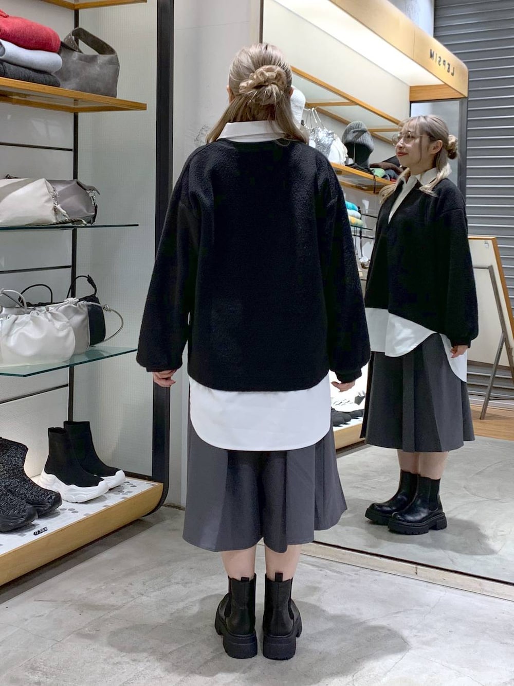 ブラック系のブーツ、ブラック系のトートバッグ、グレー系のその他パンツを着用したレディースの冬コーディネートの2枚目の写真