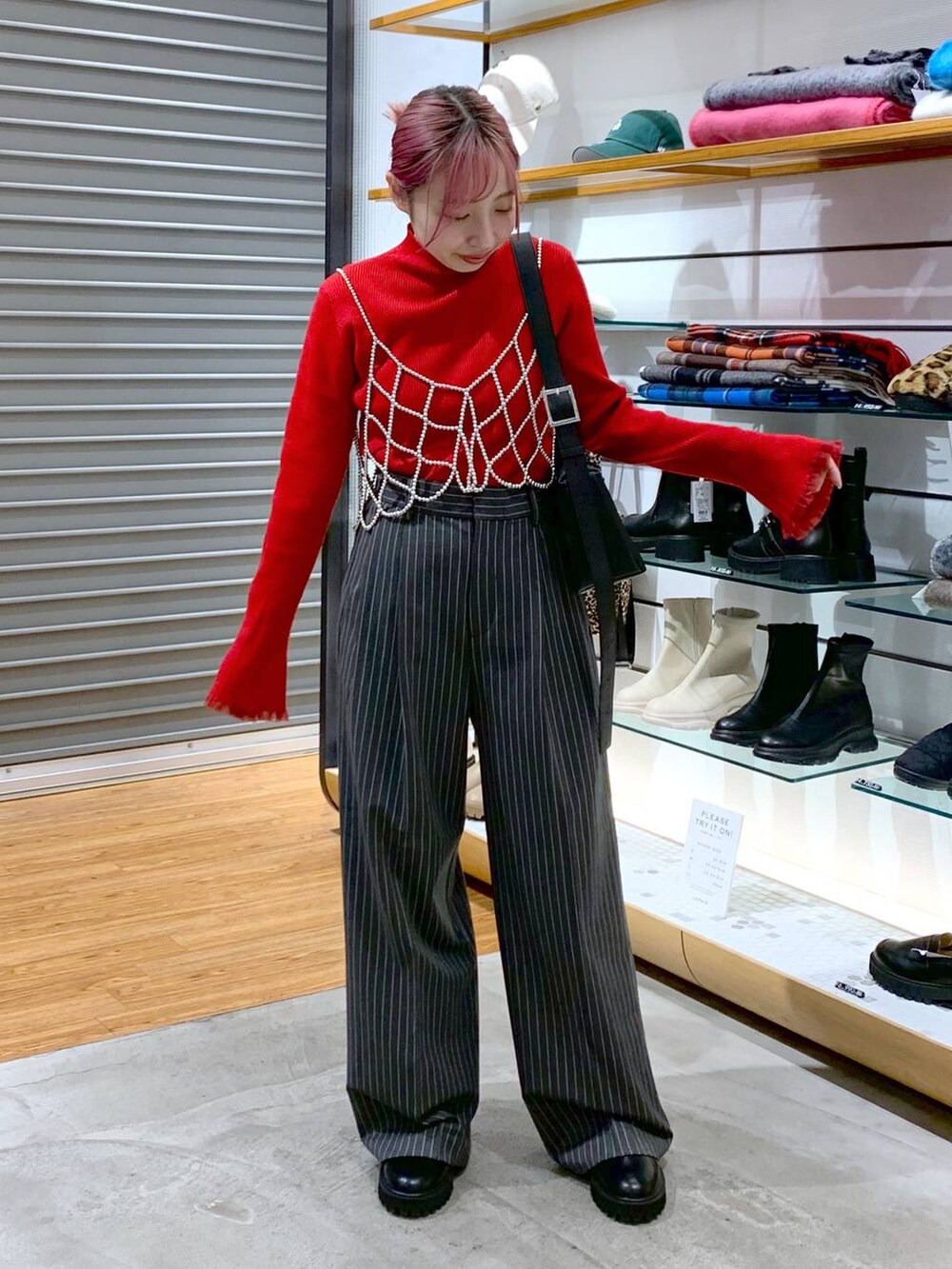 ホワイト系のベスト、ブラック系のブーツ、ブラック系のショルダーバッグを着用したレディースの冬コーディネートの7枚目の写真