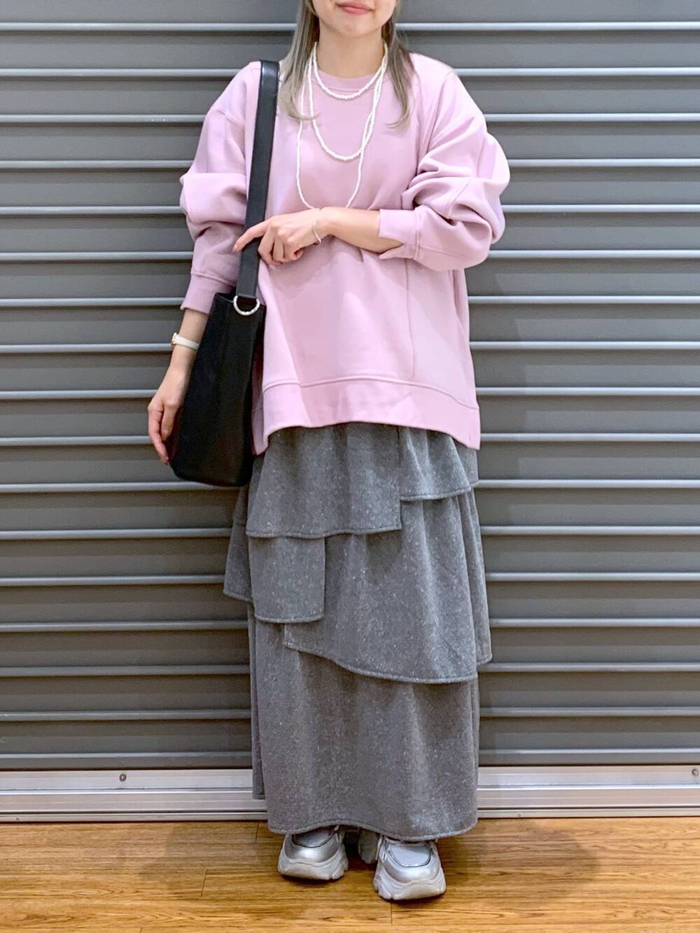 ブラック系のショルダーバッグ、ピンク系のスウェット、シルバー系のスニーカーを着用したレディースの秋コーディネートの4枚目の写真