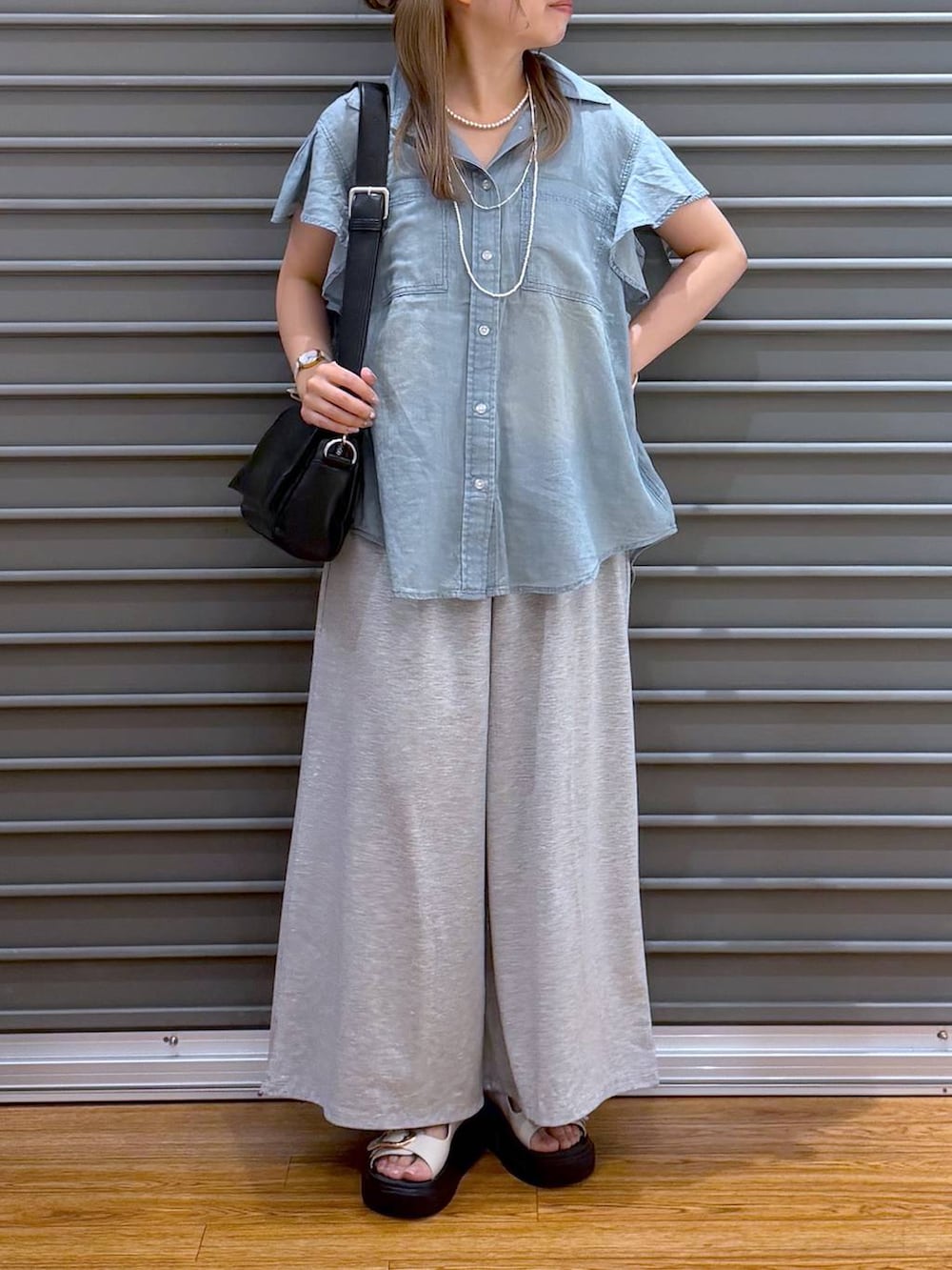 グレー系のその他パンツ、ブラック系のショルダーバッグ、ホワイト系のサンダルを着用したレディースの夏コーディネートの6枚目の写真