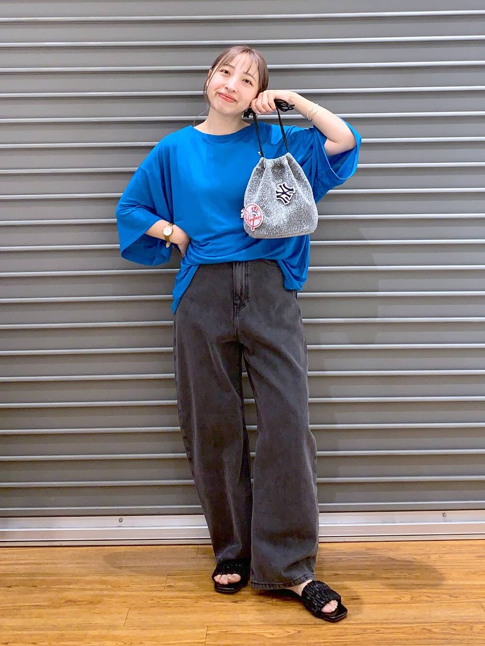 ブルー系のTシャツ/カットソー、グレー系のショルダーバッグ、ブラック系のデニムパンツを着用したレディースの夏コーディネートの7枚目の写真