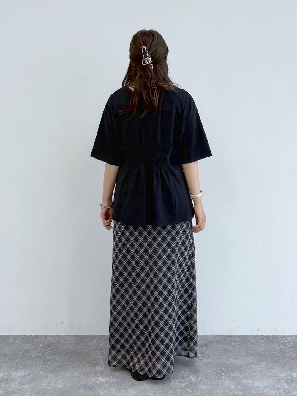 ブラック系のサンダル、ブラック系のスカート、ブラック系のTシャツ/カットソーを着用したレディースの夏コーディネートの2枚目の写真