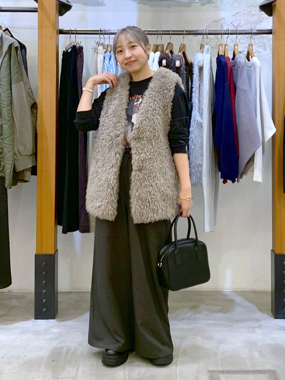 グレー系のその他パンツ、ブラック系のボストンバッグ、グレー系のベストを着用したレディースの秋コーディネートの5枚目の写真