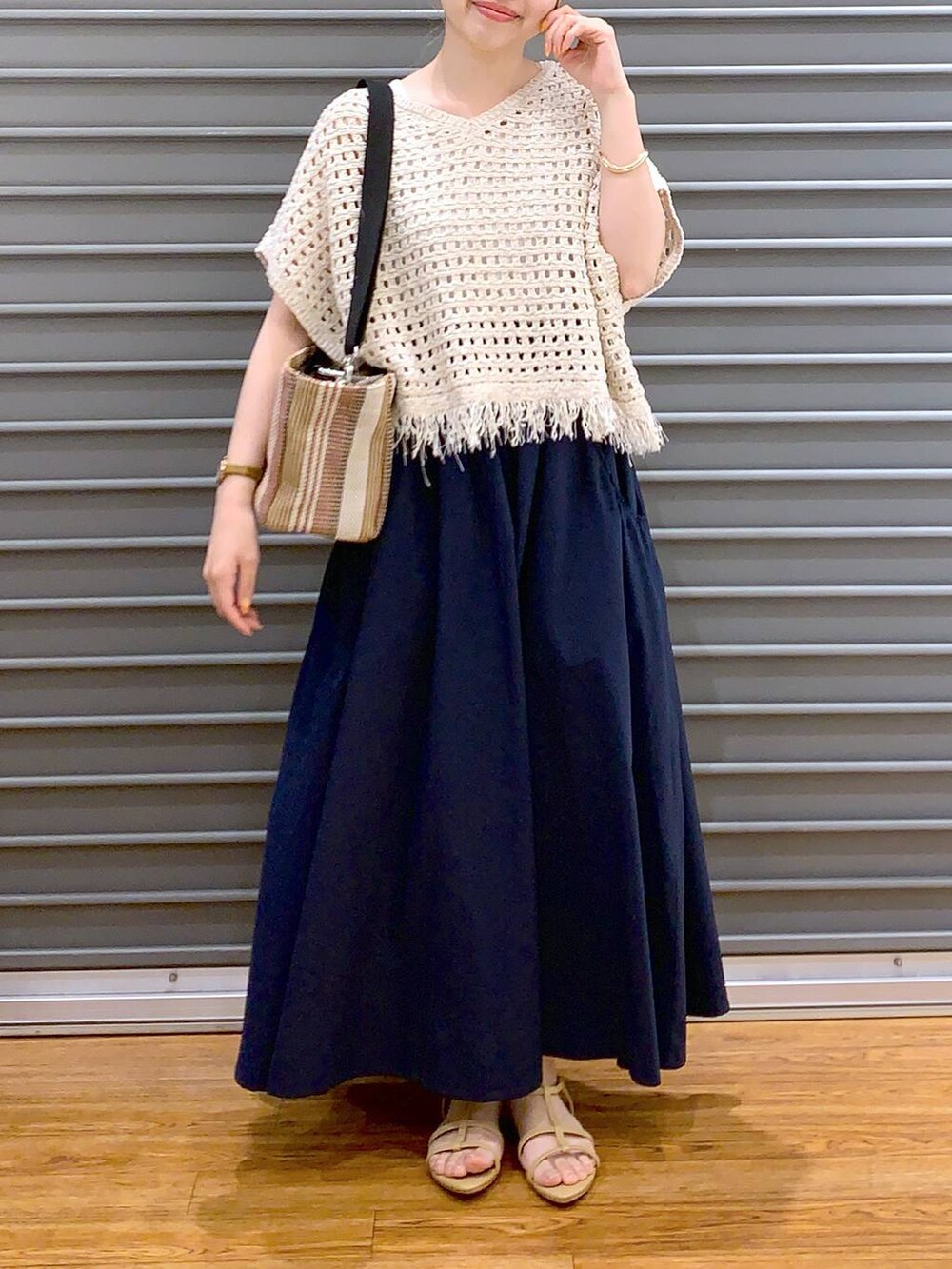 ベージュ系のサンダル、ブラウン系のショルダーバッグ、ブルー系のスカートを着用したレディースの春コーディネートの3枚目の写真