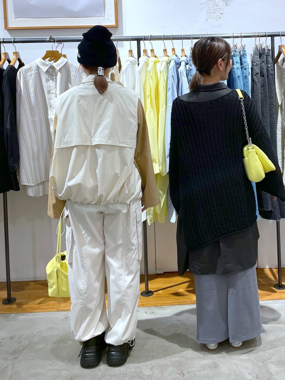 ブラック系のスニーカー、イエロー系のショルダーバッグ、ホワイト系のベストを着用したレディースの春コーディネートの2枚目の写真