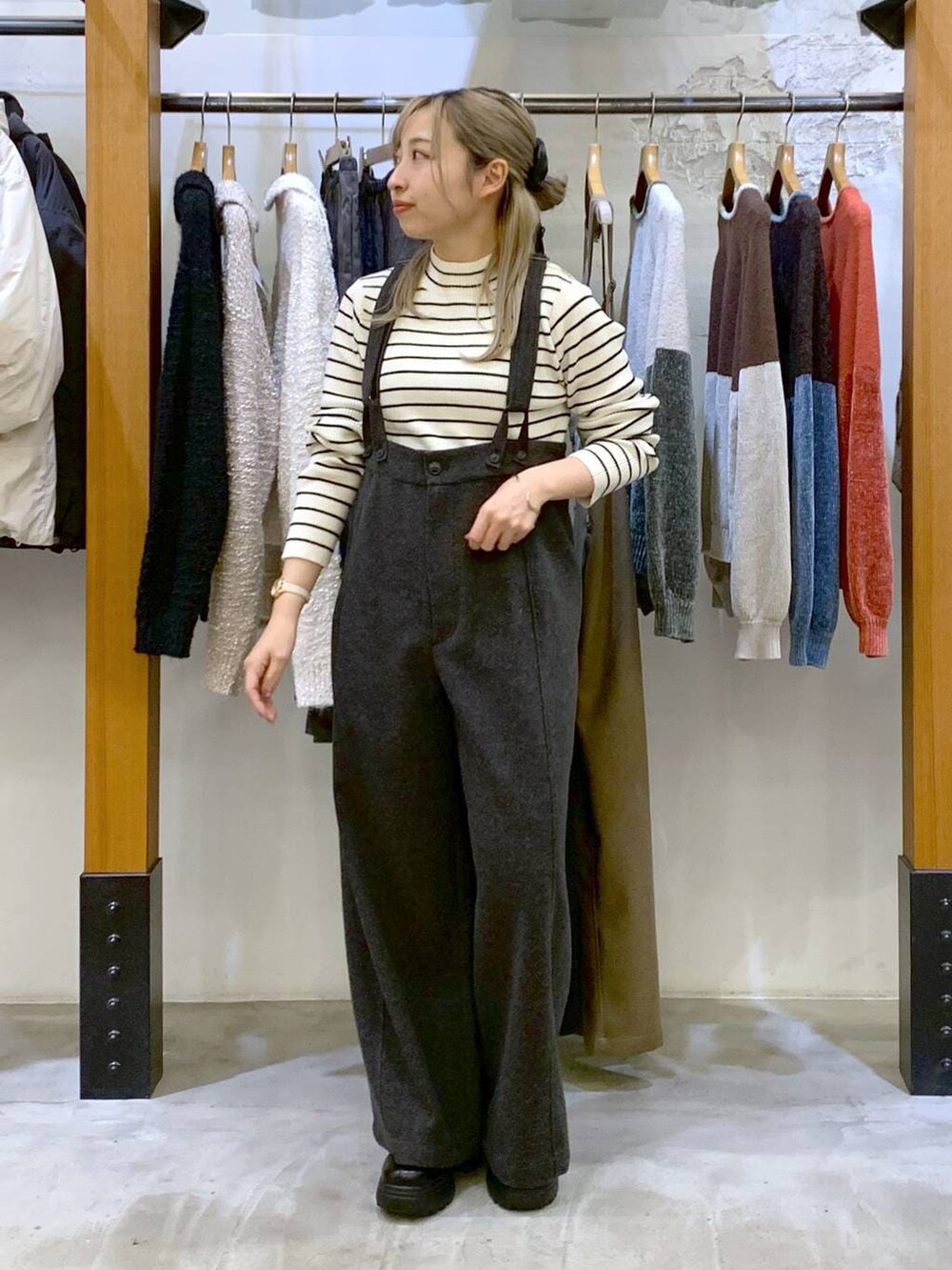 グレー系のその他パンツ、ホワイト系のニット/セーター、ブラック系のブーツを着用したレディースの秋コーディネートの7枚目の写真