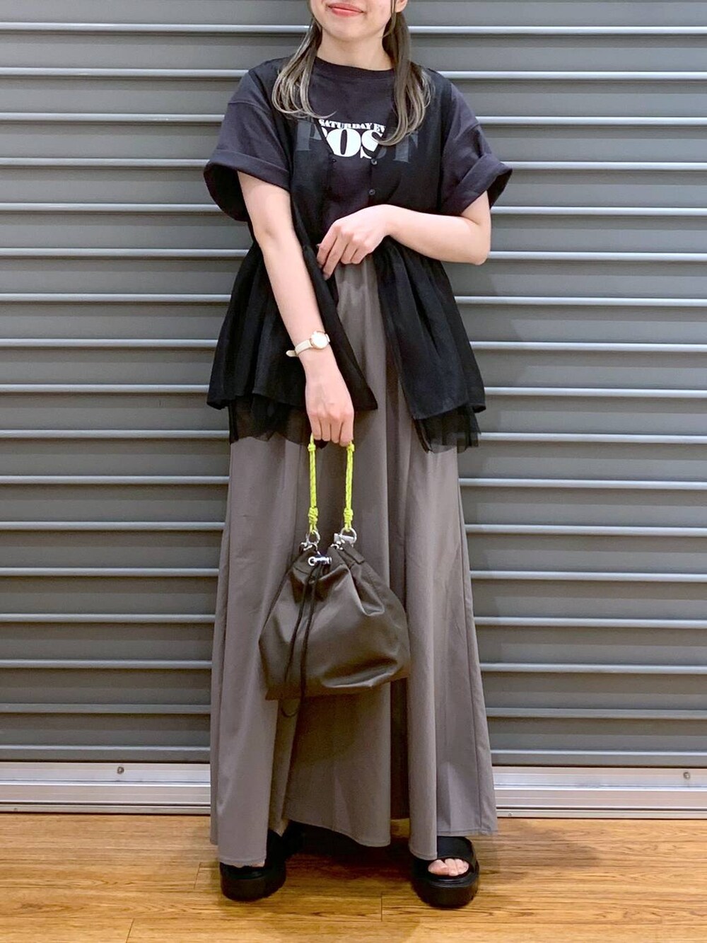 ブラック系のサンダル、ブラウン系のスカート、ブラウン系のショルダーバッグを着用したレディースの夏コーディネートの7枚目の写真