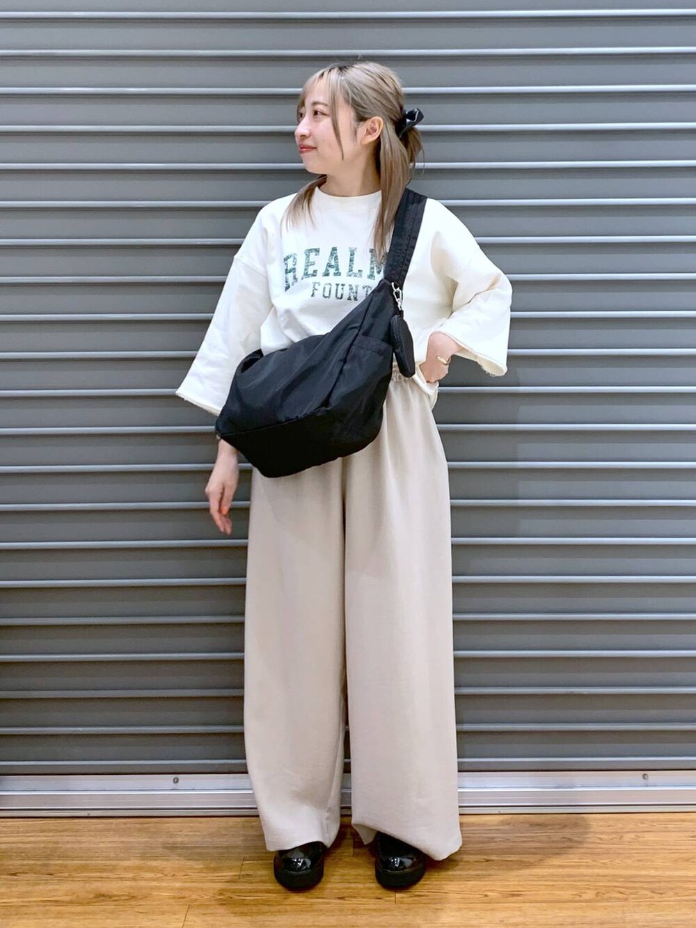 ブラック系のローファー、ブラック系のショルダーバッグ、ベージュ系のその他パンツを着用したレディースの春コーディネートの6枚目の写真