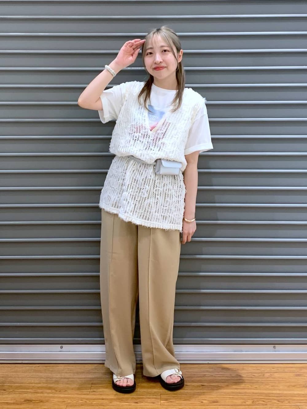 ベージュ系のその他パンツ、ホワイト系のベスト、ホワイト系のサンダルを着用したレディースの春コーディネートの3枚目の写真