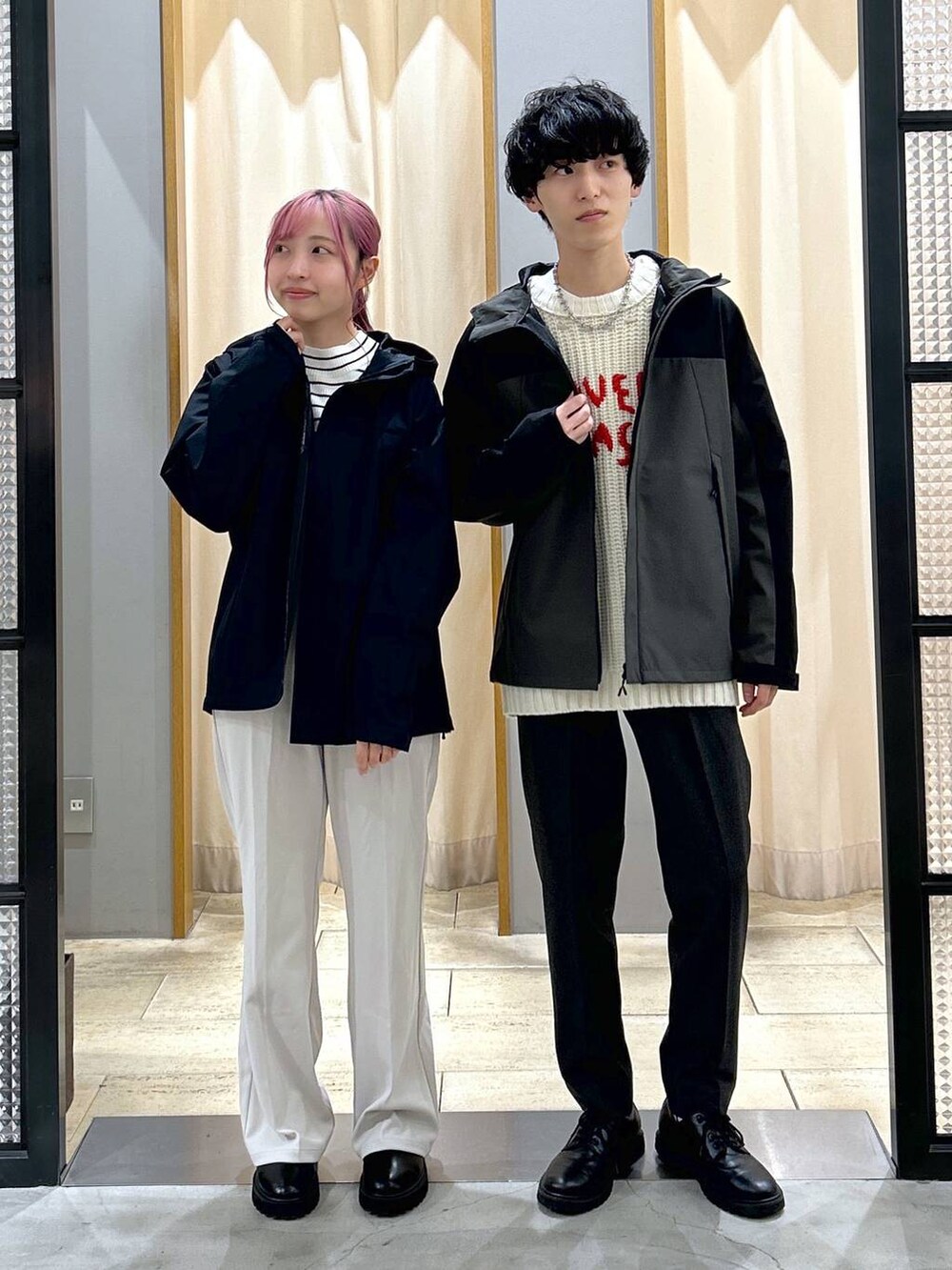 グレー系のスラックス、ブラック系のブーツ、ホワイト系のニット/セーターを着用したレディースの冬コーディネートの3枚目の写真