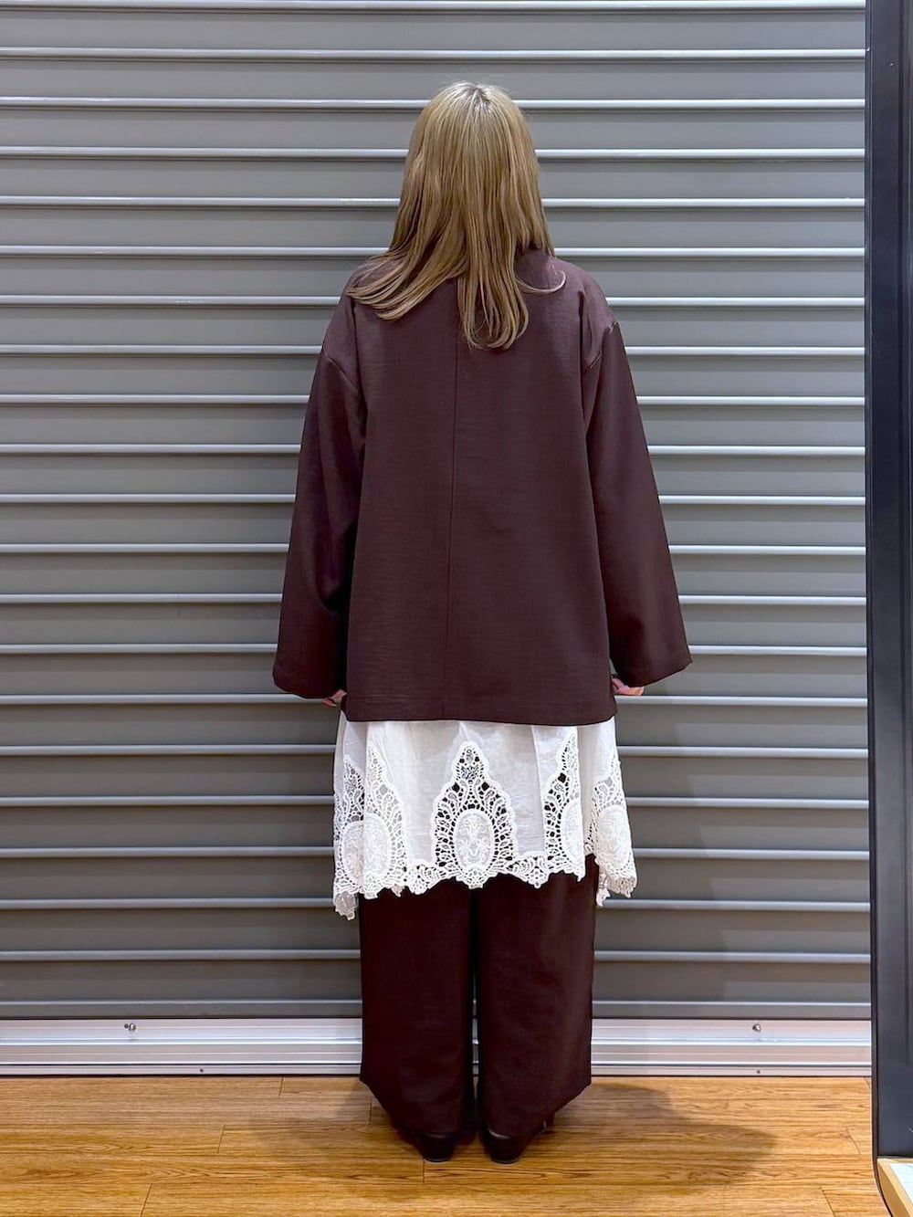 ブラック系のボストンバッグ、ホワイト系のキャミソール、ブラウン系のその他パンツを着用したレディースの春コーディネートの2枚目の写真