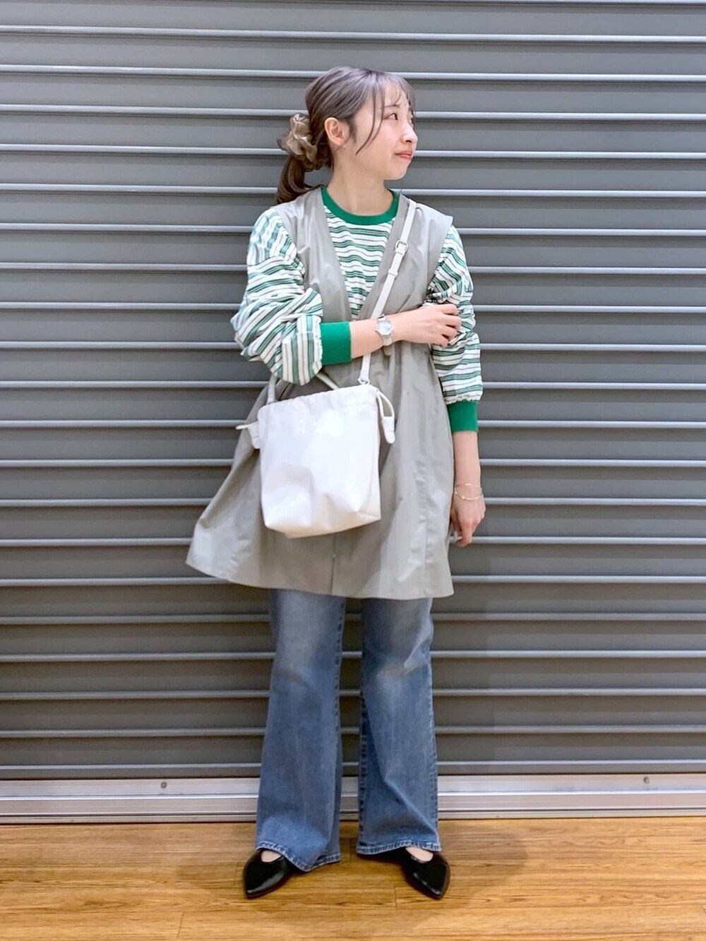 グリーン系のワンピース、ブルー系のデニムパンツ、ブラック系のパンプスを着用したレディースの春コーディネートの8枚目の写真