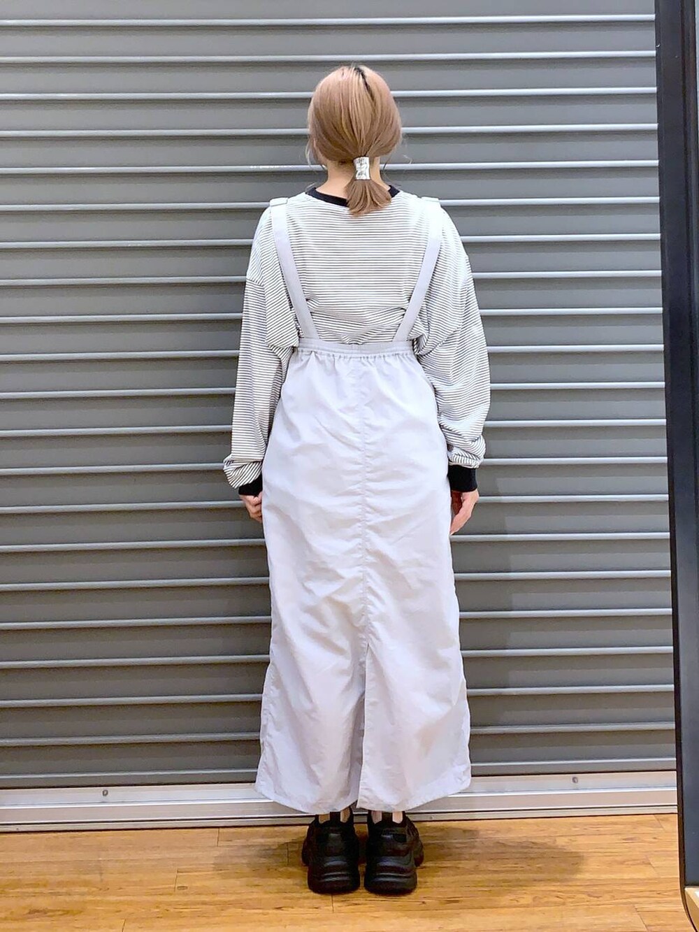 ブラック系のスニーカー、グレー系のTシャツ/カットソー、グレー系のスカートを着用したレディースの春コーディネートの2枚目の写真