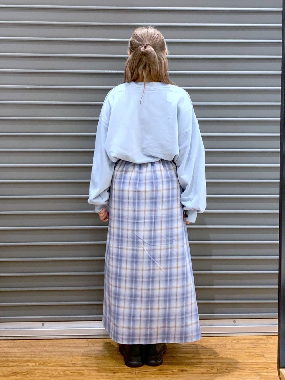 ブラック系のブーツ、ブルー系のスカート、ブルー系のスウェットを着用したレディースの冬コーディネートの2枚目の写真