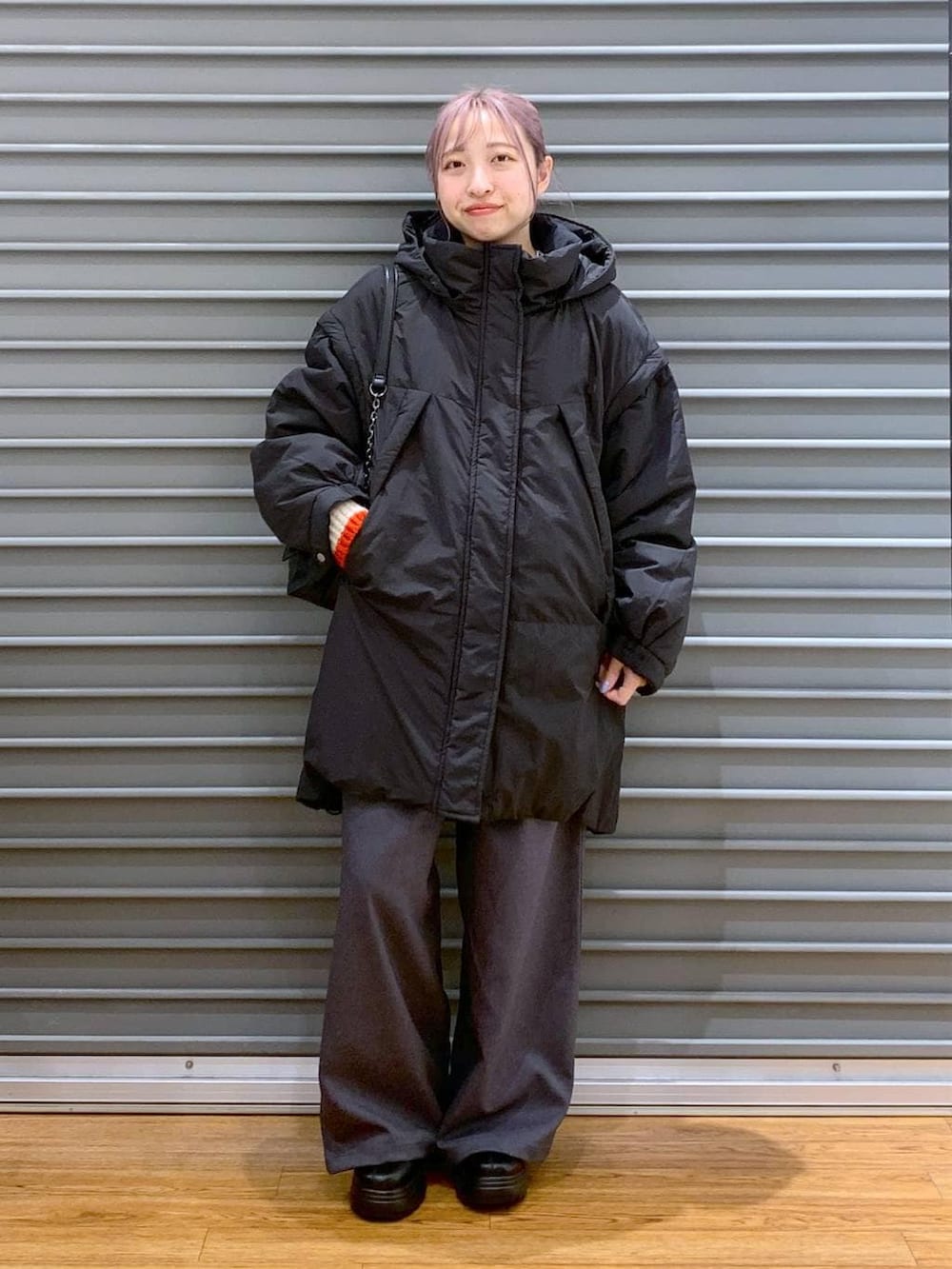 ブラック系のその他アウター、ブラック系のブーツ、ブラック系のショルダーバッグを着用したレディースの冬コーディネートの8枚目の写真