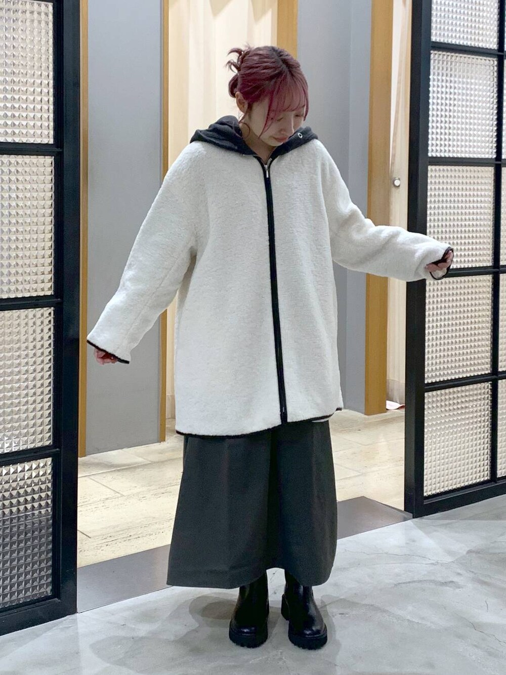 ブラック系のブーツ、ホワイト系のその他アウター、グレー系のワンピースを着用したレディースの秋コーディネートの3枚目の写真