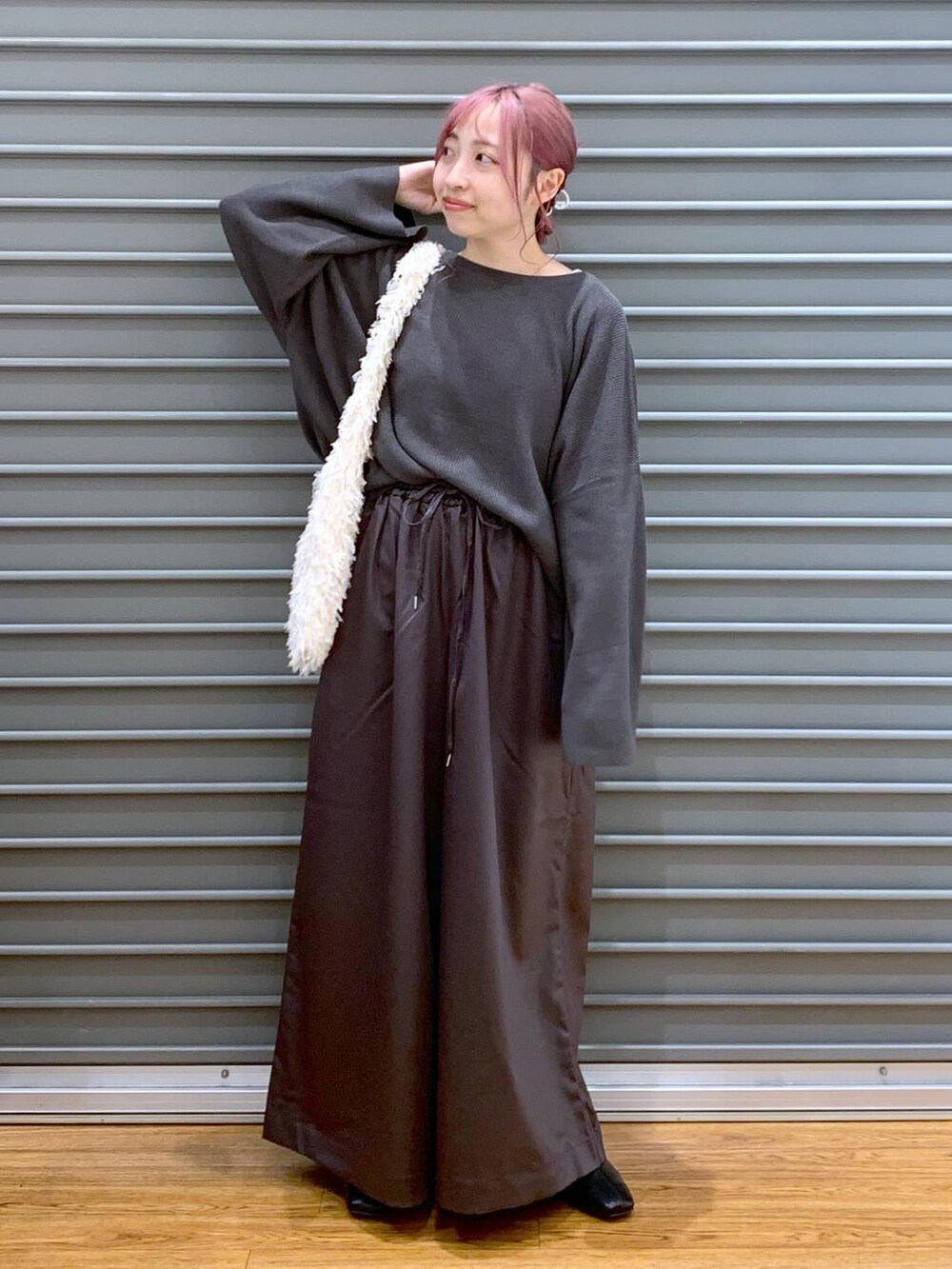 ホワイト系のショルダーバッグ、グレー系のニット/セーター、ブラック系のブーツを着用したレディースの秋コーディネートの3枚目の写真