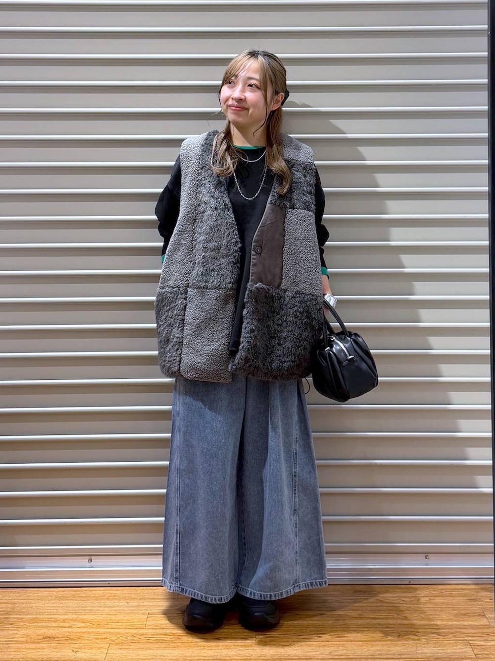 ブラック系のショルダーバッグ、ブラック系のスニーカー、ブラック系のTシャツ/カットソーを着用したレディースの秋コーディネートの6枚目の写真