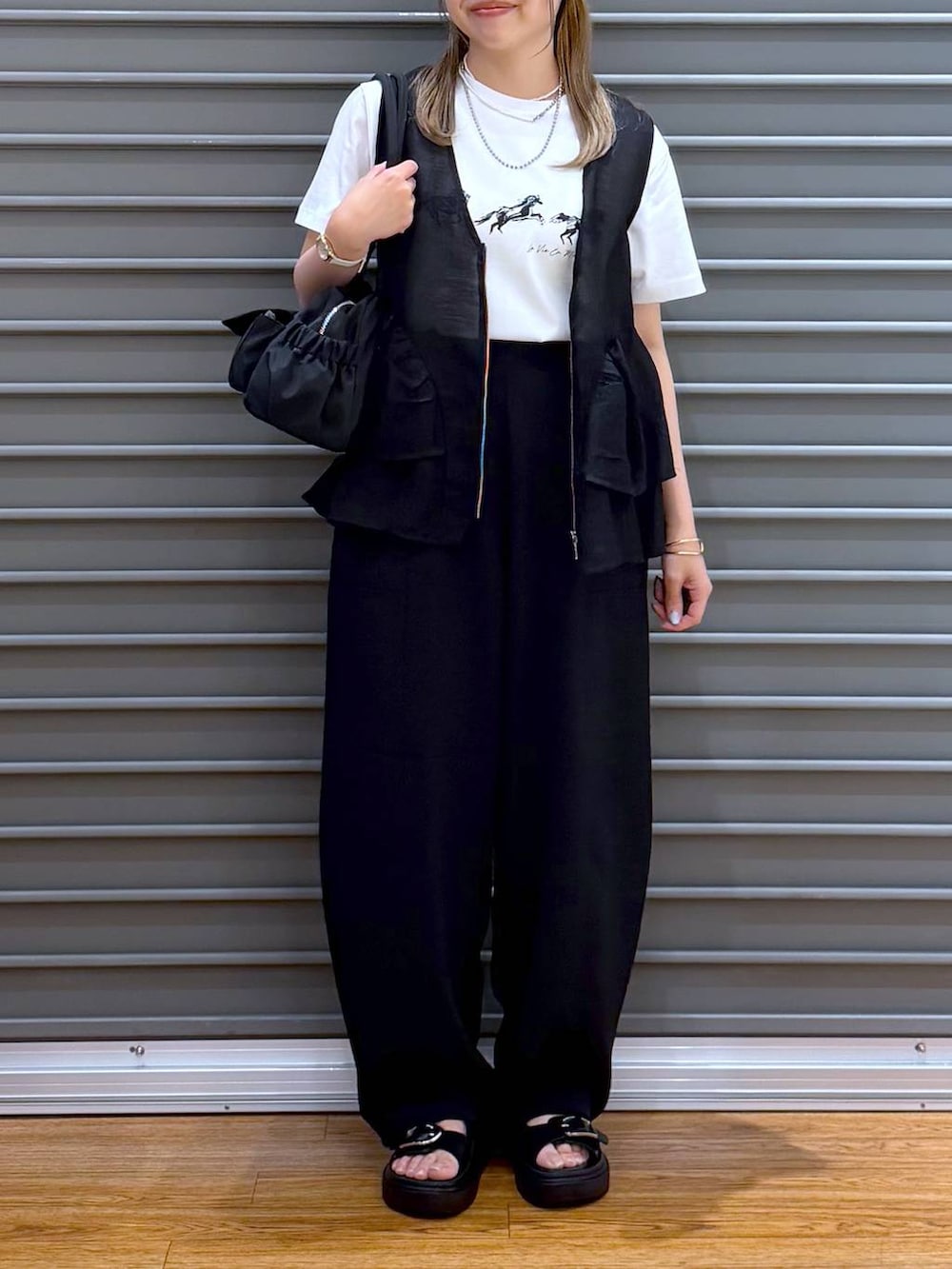 ブラック系のサンダル、ブラック系のその他パンツ、ブラック系のボストンバッグを着用したレディースの春コーディネートの7枚目の写真