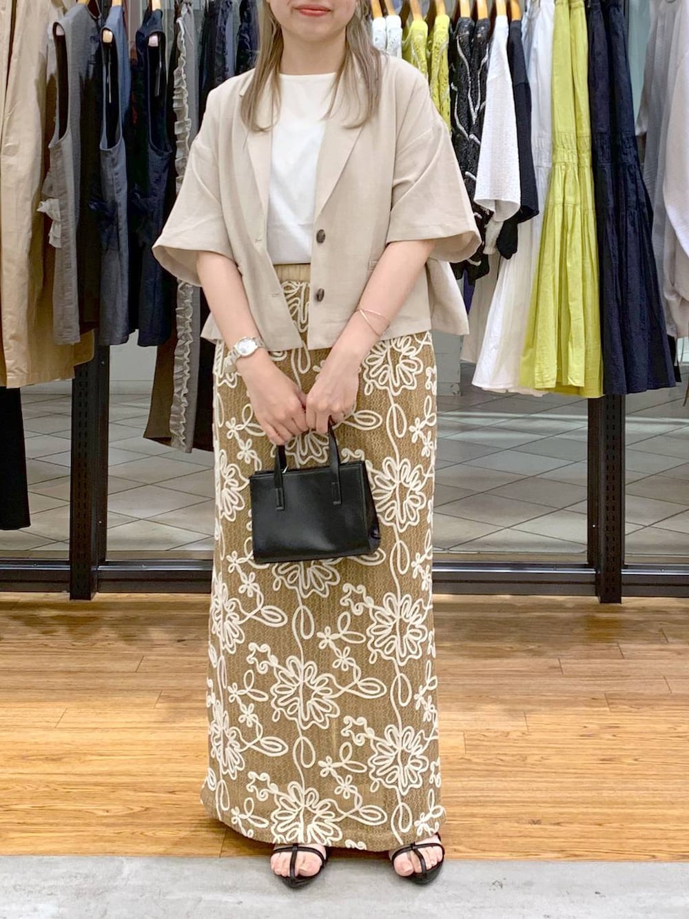 ホワイト系のTシャツ/カットソー、ブラック系のサンダル、ブラック系のショルダーバッグを着用したレディースの春コーディネートの6枚目の写真