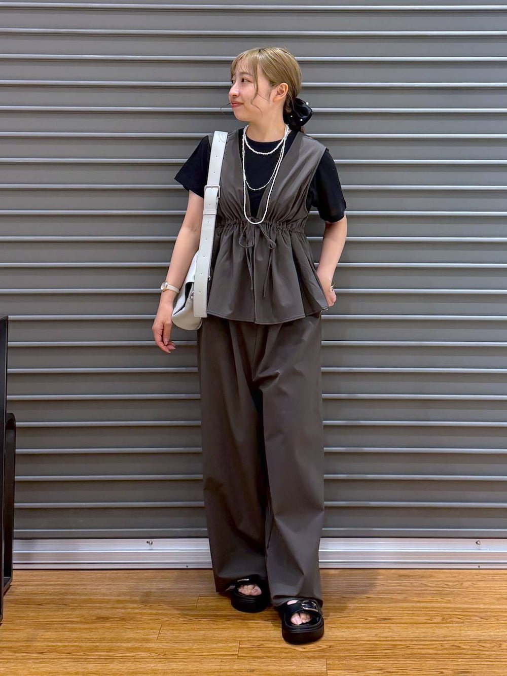 ブラック系のTシャツ/カットソー、グレー系のショルダーバッグ、ブラック系のサンダルを着用したレディースの春コーディネートの4枚目の写真