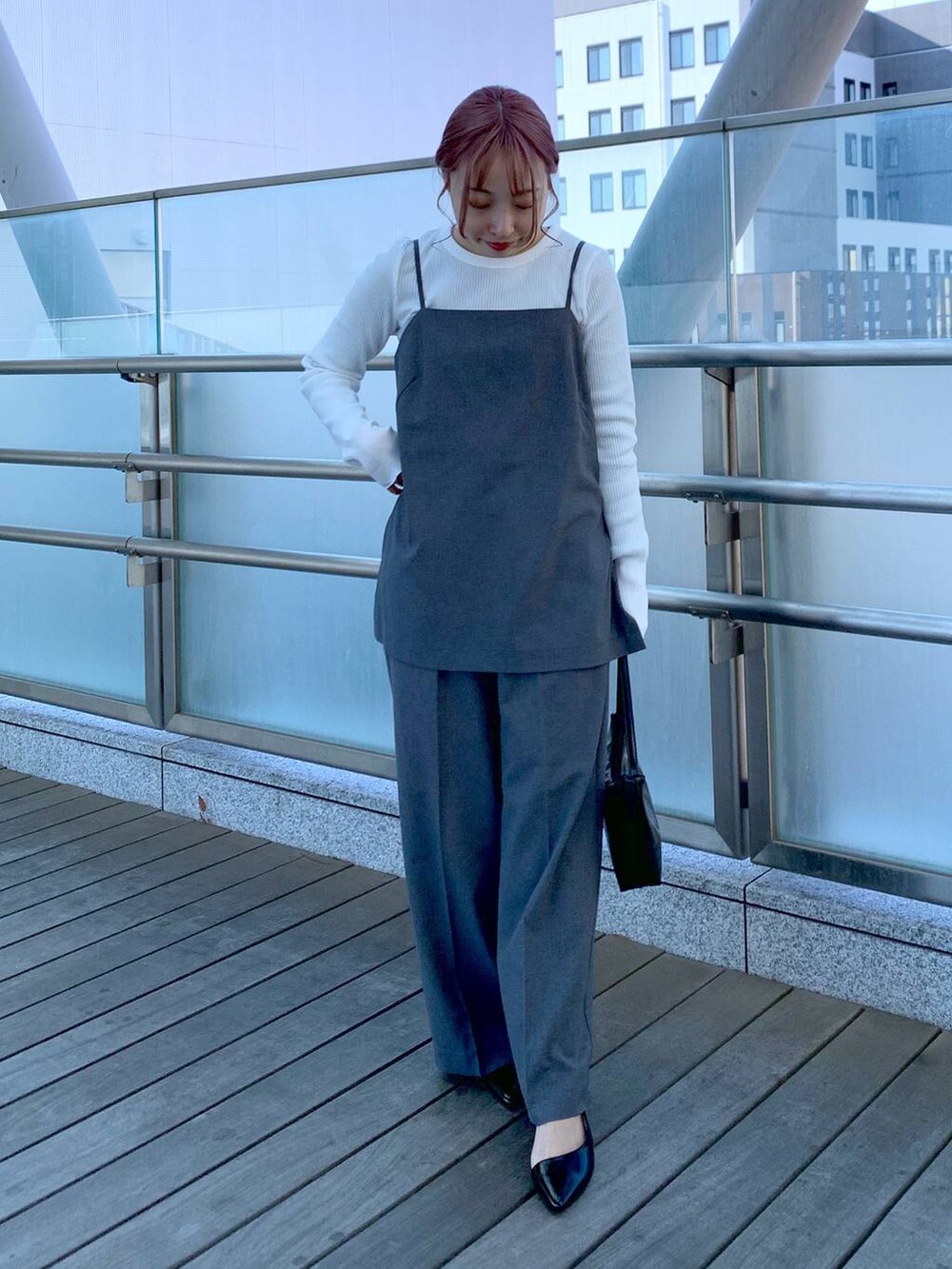 ブラック系のハンドバッグ、ホワイト系のTシャツ/カットソー、グレー系のキャミソールを着用したレディースの春コーディネートの4枚目の写真