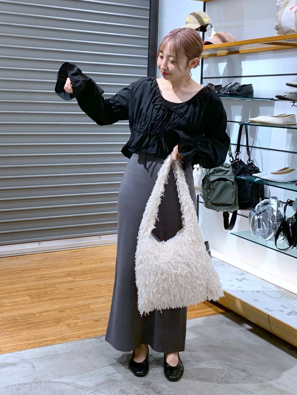 ホワイト系のショルダーバッグ、ブラック系のパンプス、グレー系のスカートを着用したレディースの秋コーディネートの4枚目の写真