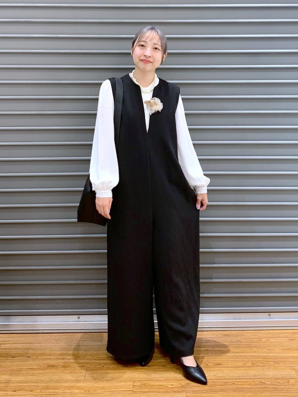 ホワイト系のシャツ/ブラウス、ブラック系のサロペット/オーバーオール、ブラック系のパンプスを着用したレディースの冬コーディネートの3枚目の写真