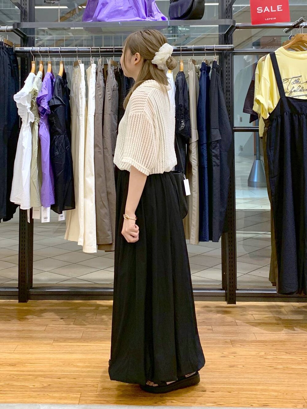 ブラック系のサンダル、ブラック系のスカート、ホワイト系のポロシャツを着用したレディースの夏コーディネートの3枚目の写真