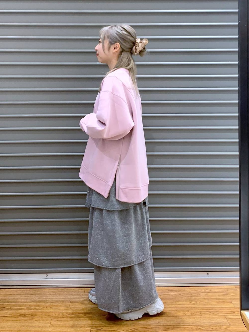 ブラック系のショルダーバッグ、ピンク系のスウェット、シルバー系のスニーカーを着用したレディースの秋コーディネートの3枚目の写真