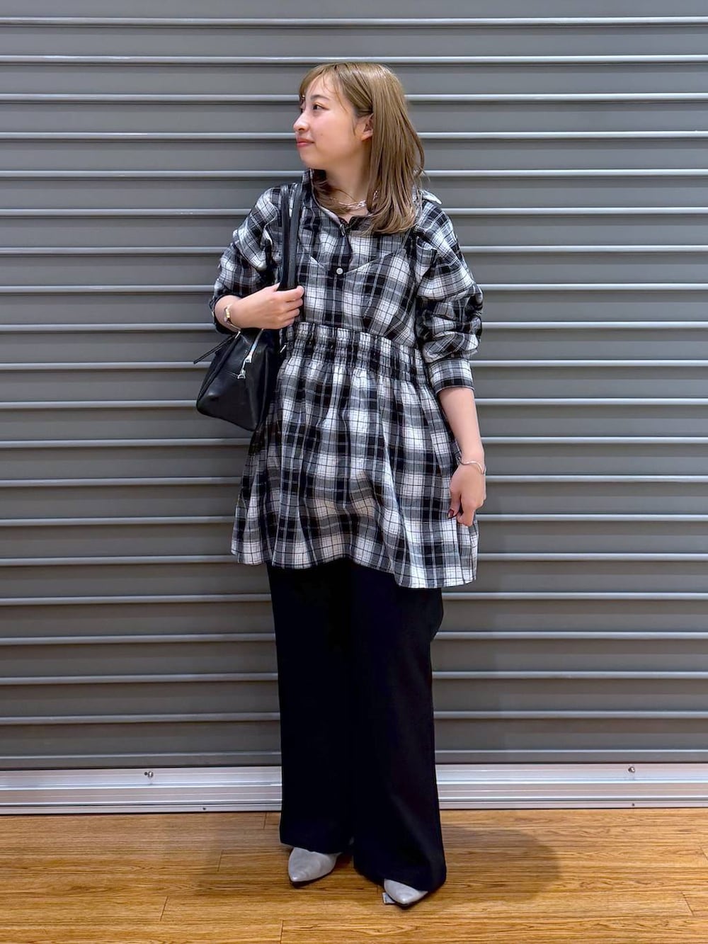 ブラック系のボストンバッグ、シルバー系のパンプス、ブラック系のスウェットパンツを着用したレディースの春コーディネートの5枚目の写真