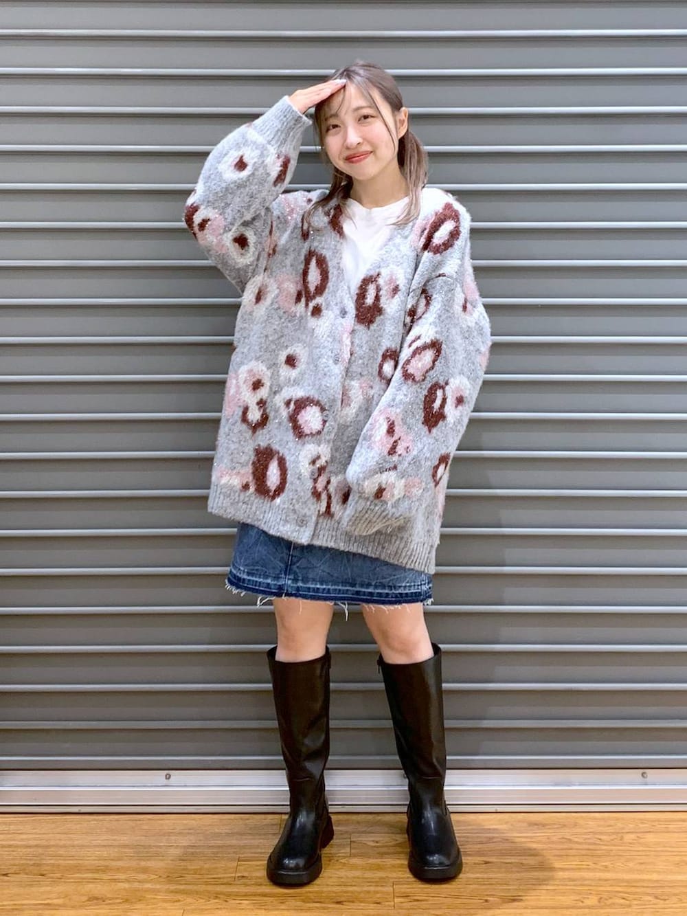 ブルー系のデニムスカート、ブラック系のショルダーバッグ、ブラック系のブーツを着用したレディースの冬コーディネートの3枚目の写真