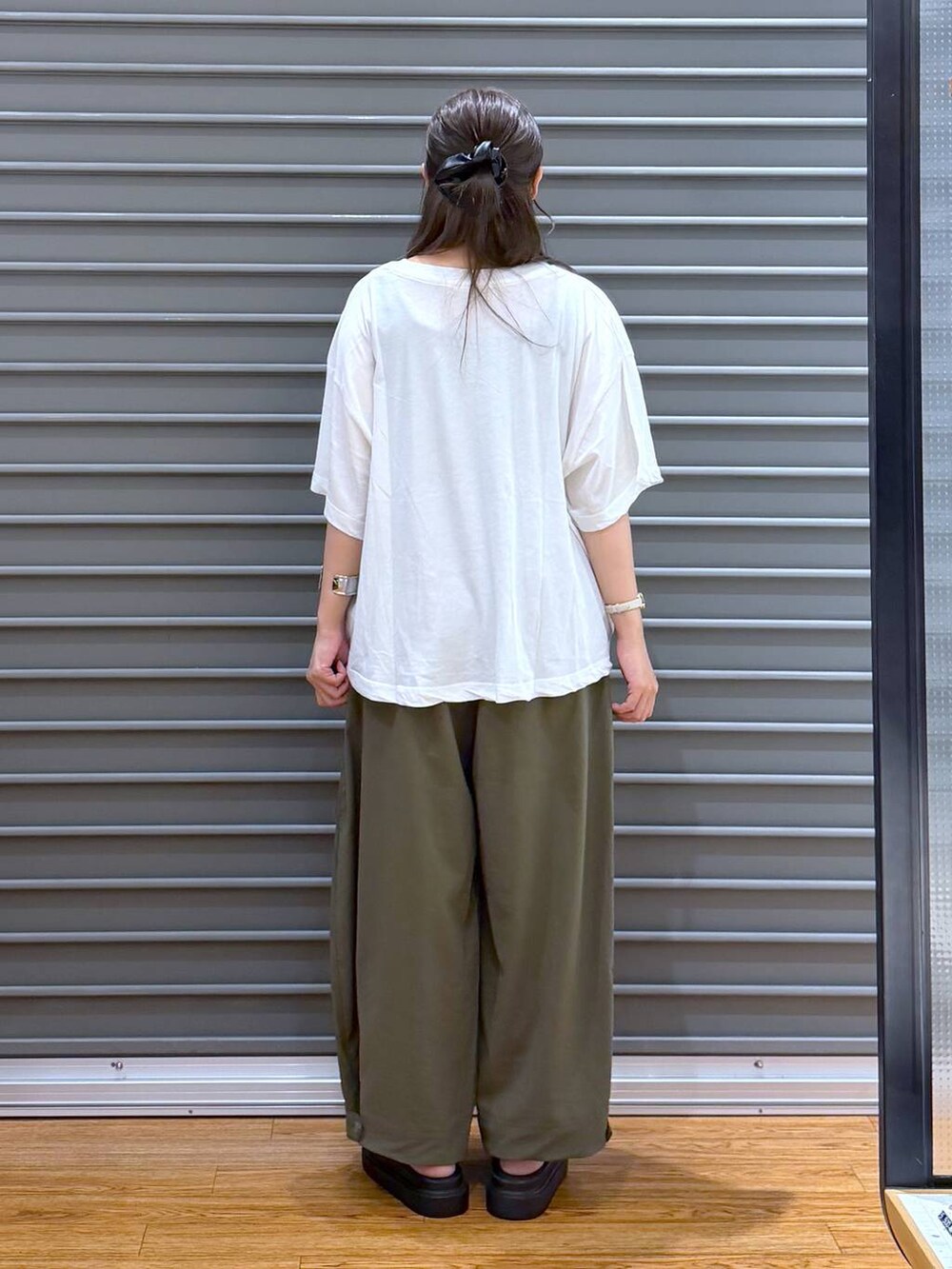 ブルー系のトートバッグ、ホワイト系のTシャツ/カットソー、ブラック系のサンダルを着用したレディースの夏コーディネートの2枚目の写真
