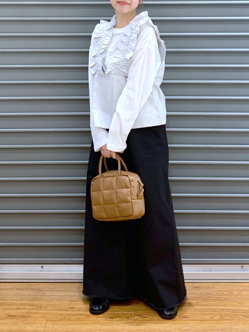 ホワイト系のTシャツ/カットソー、グレー系のスカート、ブラウン系のボストンバッグを着用したレディースの秋コーディネートの5枚目の写真