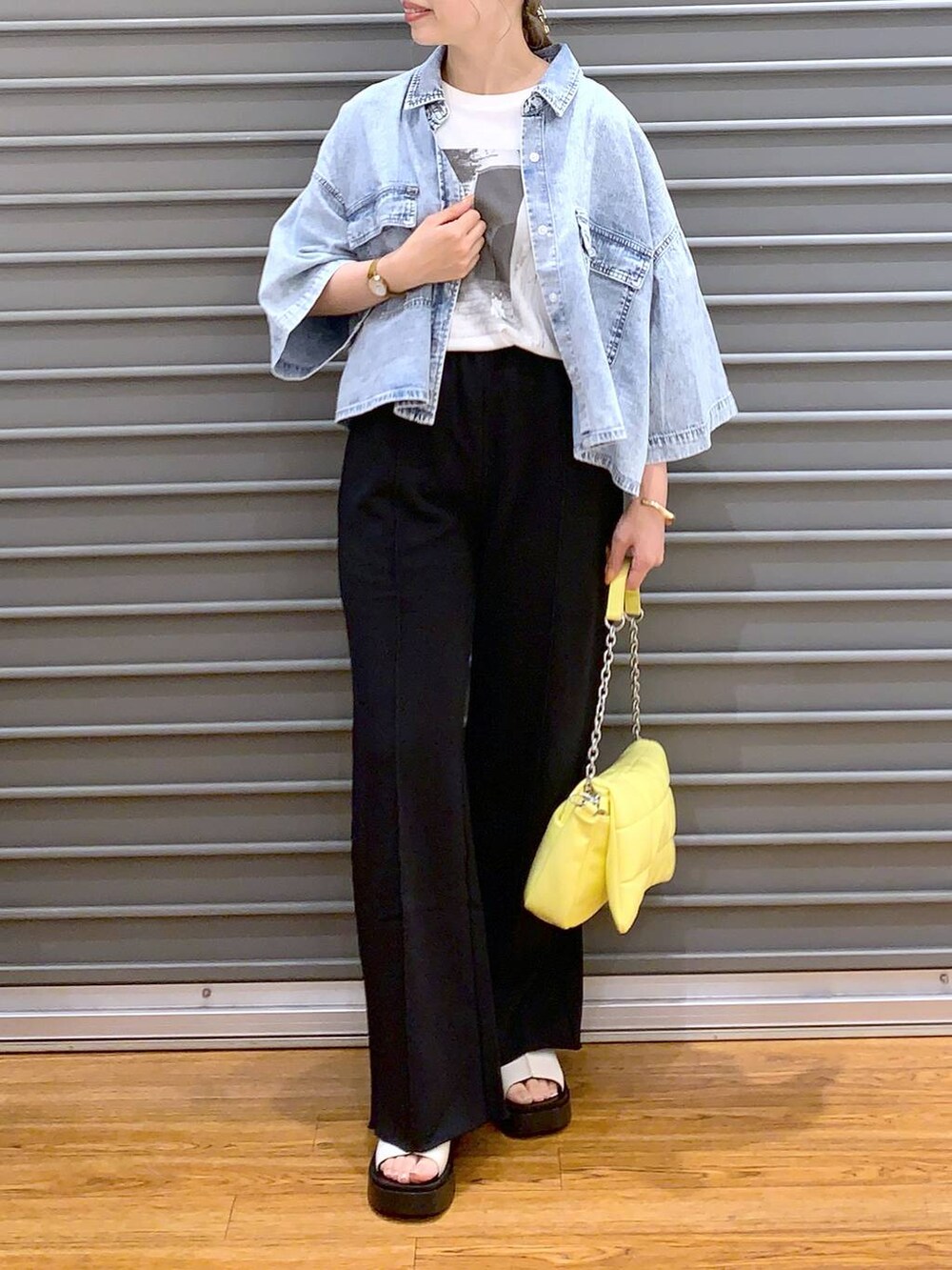イエロー系のショルダーバッグ、ブルー系のシャツ/ブラウス、ホワイト系のサンダルを着用したレディースの春コーディネートの6枚目の写真