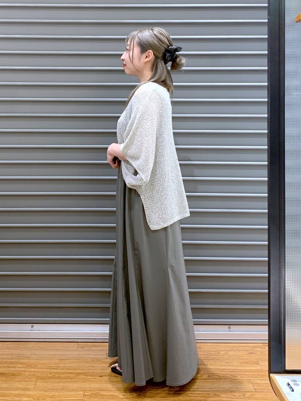 ベージュ系のニット/セーター、ホワイト系のサンダル、ベージュ系のトートバッグを着用したレディースの夏コーディネートの3枚目の写真