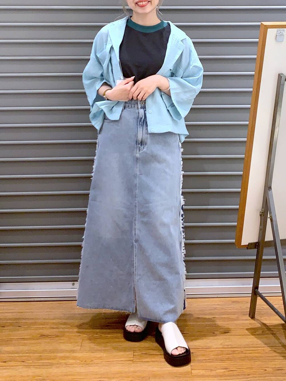 グレー系のタンクトップ、グレー系のショルダーバッグ、ホワイト系のサンダルを着用したレディースの夏コーディネートの6枚目の写真