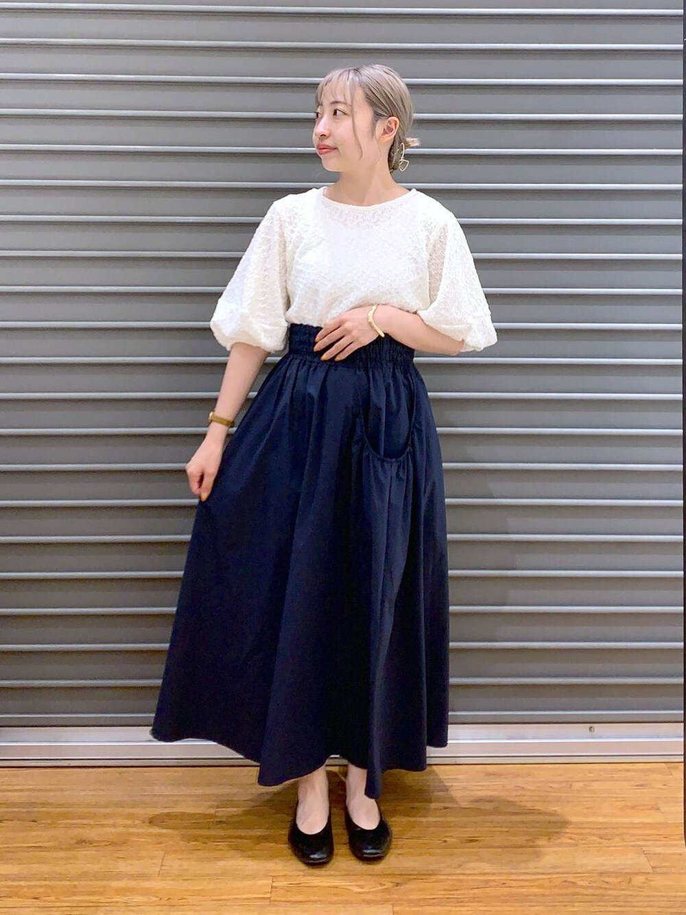 ホワイト系のショルダーバッグ、ブラック系のパンプス、ブルー系のスカートを着用したレディースの春コーディネートの6枚目の写真