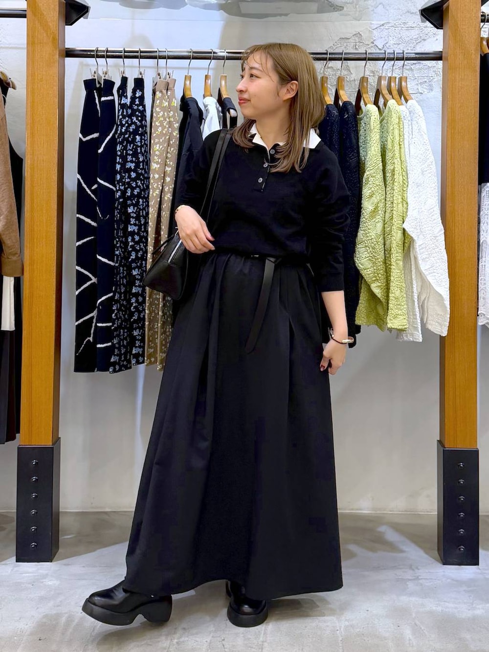 ブラック系のサンダル、ブラック系のボストンバッグ、ブラック系のスカートを着用したレディースの春コーディネートの6枚目の写真