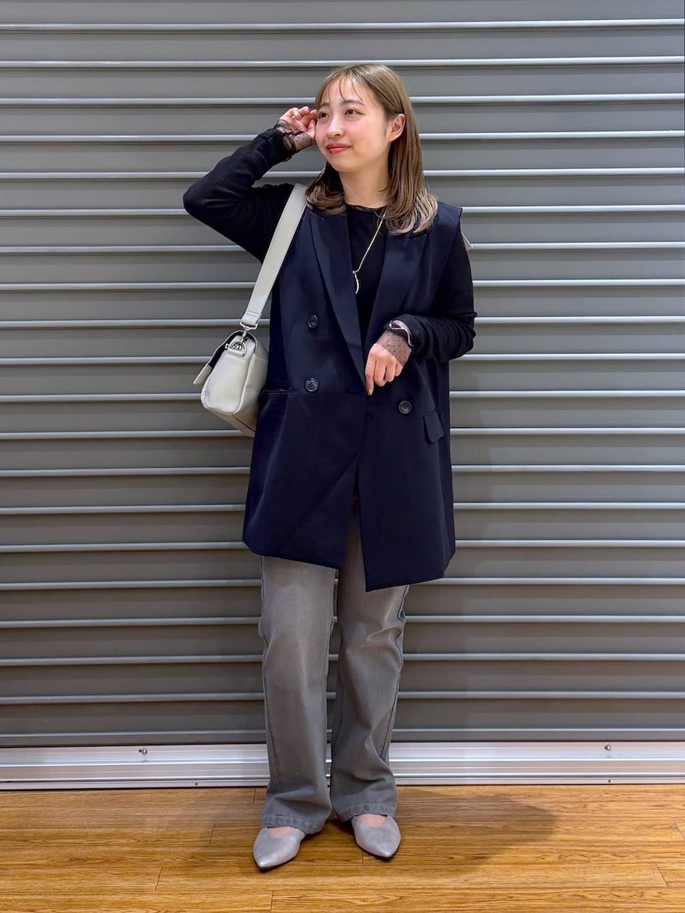 グレー系のショルダーバッグ、ブルー系のその他アウター、ブラック系のTシャツ/カットソーを着用したレディースの冬コーディネートの5枚目の写真