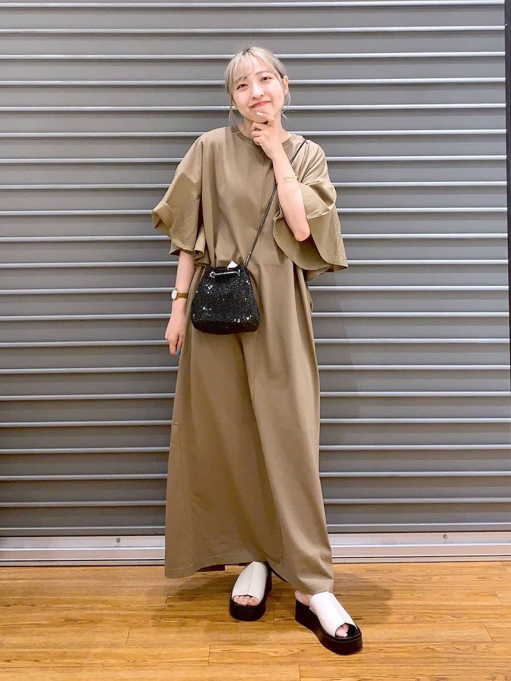 ブラック系のショルダーバッグ、ホワイト系のサンダル、ベージュ系のワンピースを着用したレディースの夏コーディネートの3枚目の写真