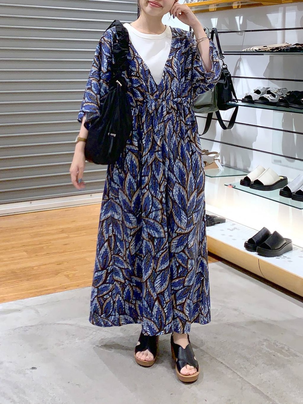 ブラック系のショルダーバッグ、ブラック系のサンダル、ホワイト系のタンクトップを着用したレディースの夏コーディネートの5枚目の写真