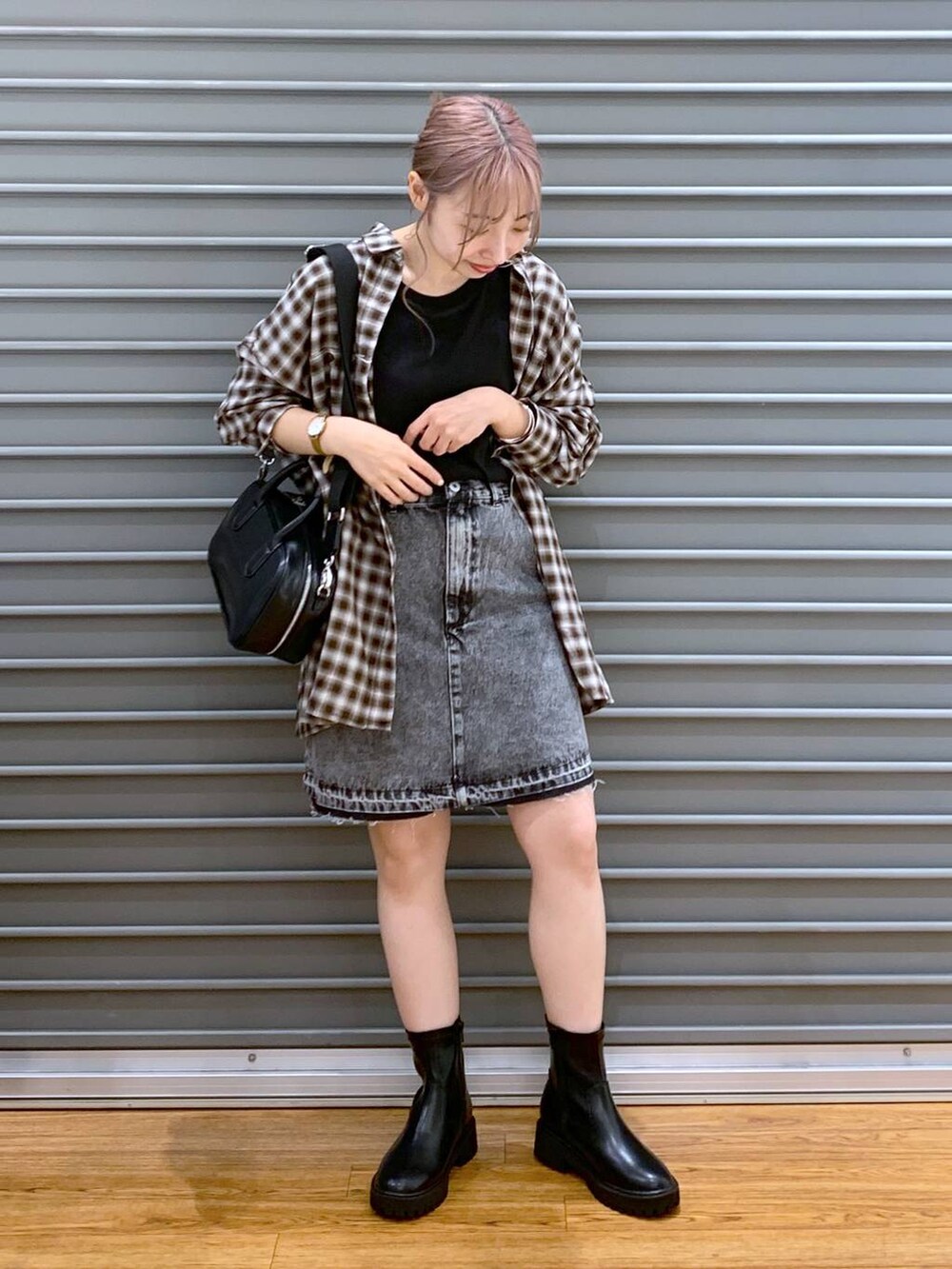 ブラック系のTシャツ/カットソー、ブラック系のボストンバッグ、ブラック系のブーツを着用したレディースの秋コーディネートの3枚目の写真