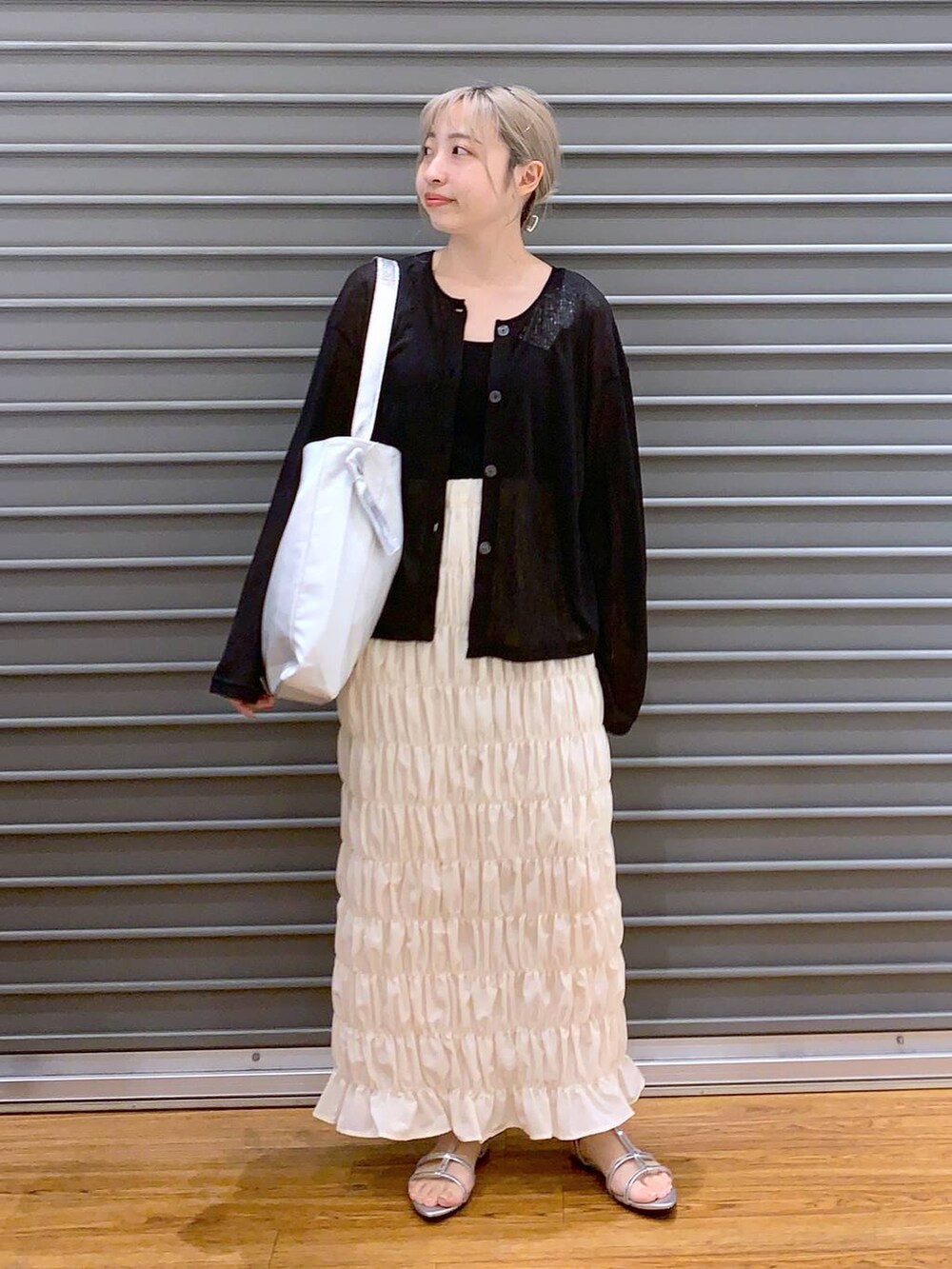 シルバー系のサンダル、ブラック系のカーディガン/ボレロ、グレー系のショルダーバッグを着用したレディースの夏コーディネートの3枚目の写真