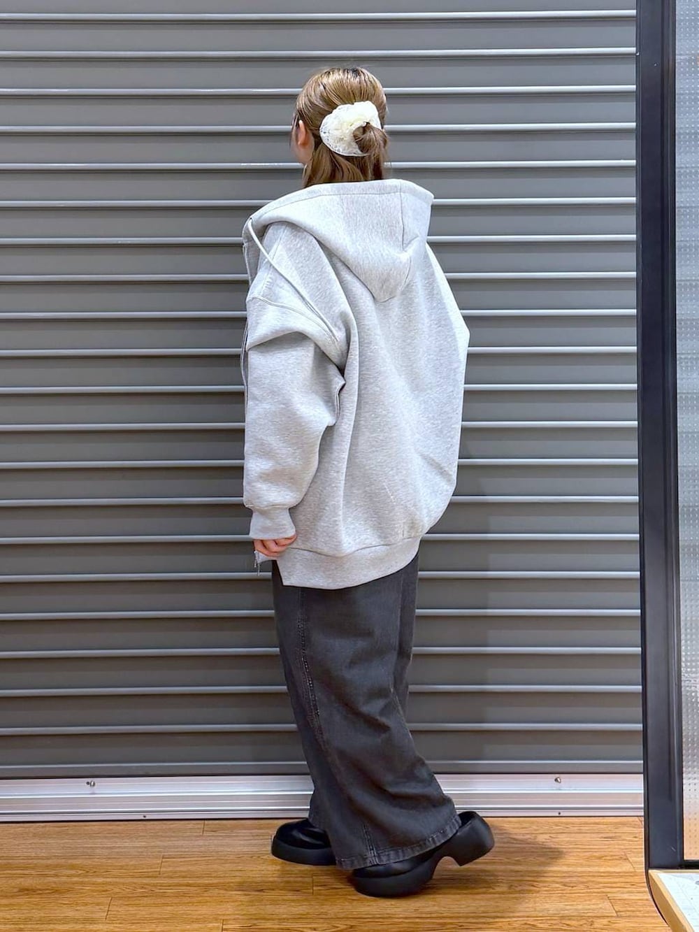 ブラック系のサンダル、ブラック系のボストンバッグ、グレー系のパーカーを着用したレディースの春コーディネートの3枚目の写真