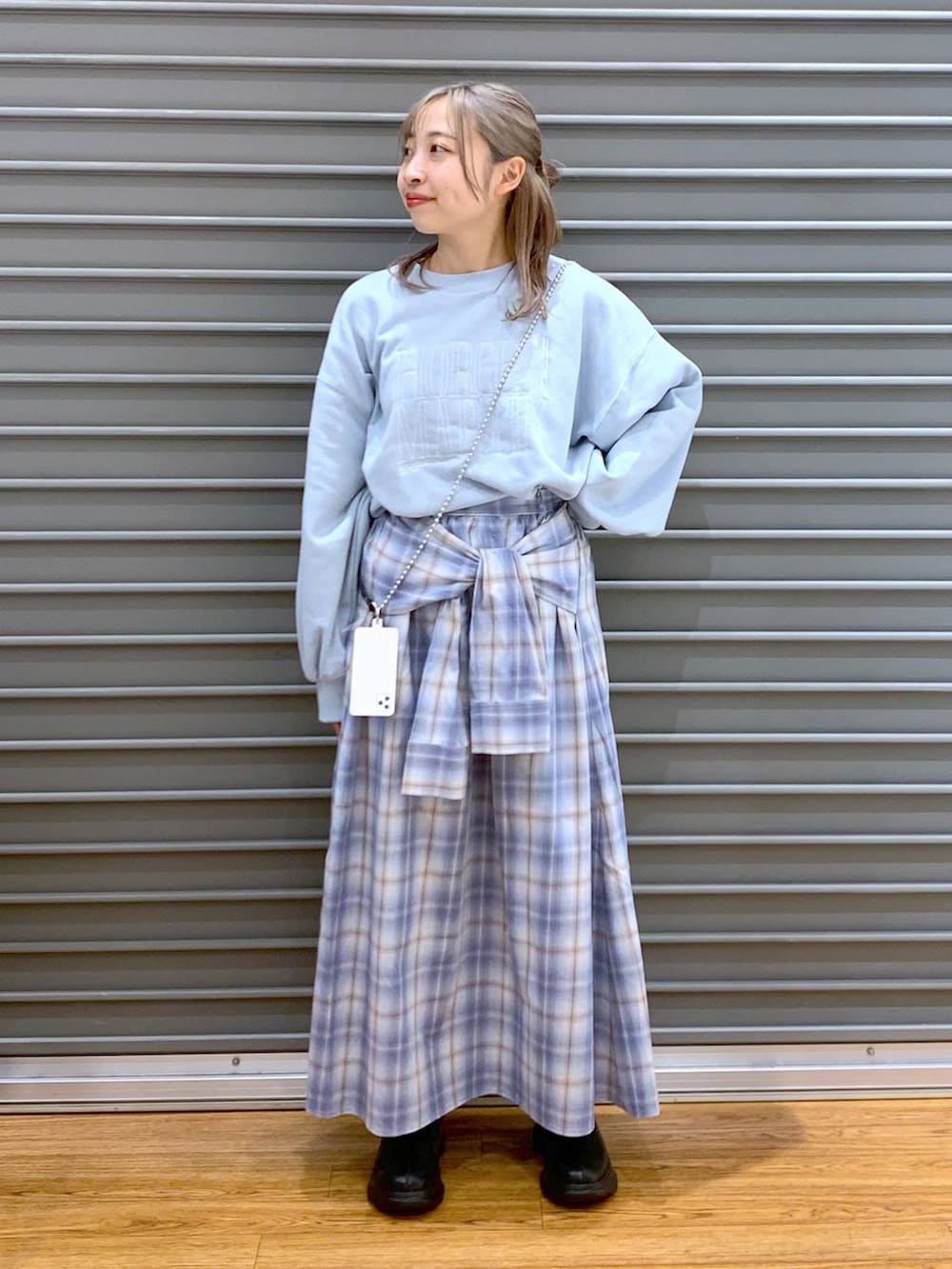 ブラック系のブーツ、ブルー系のスカート、ブルー系のスウェットを着用したレディースの冬コーディネートの3枚目の写真